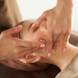 Japanese woman receiving a facial massage at an aesthetic salon